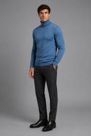 Men’s premium white roll neck knitted jumper styled with tailored trousers and black leather boots by Thorvyn