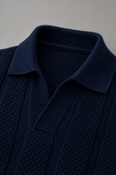 Men's textured knit polo featuring an open collar, vertical textured knit panels and ribbed trims.